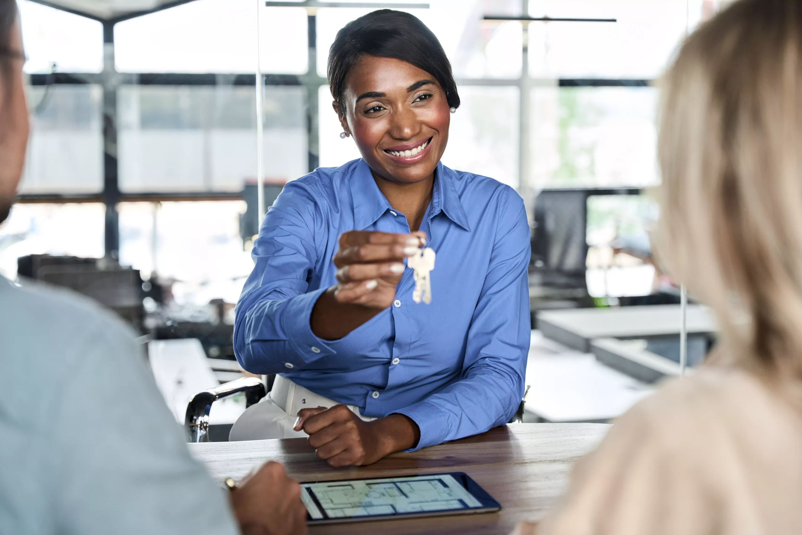 african-american-agent-giving-keys-selling-property