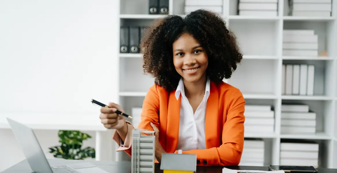 female-real-estate-agent-presenting-property-model-office